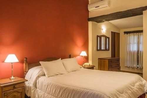诺诺诺诺大酒店的卧室配有白色大床和橙色墙壁