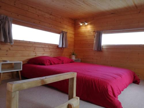 尼姆Le Petit Chalet de Nîmes Shantay Youstay的小木屋内一间卧室,配有红色的床