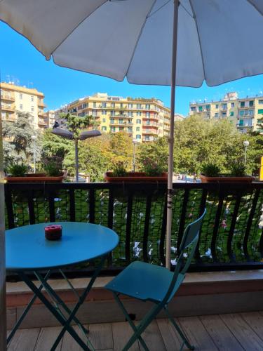 那不勒斯ESPOSITO PLAZA- ROOMS & SUITE的阳台配有蓝色桌子和椅子,配有雨伞