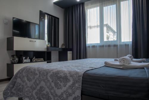 大特尔诺沃Apartment Central-LUX 1的一间卧室配有一张床、电视和毛巾