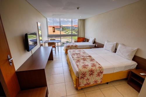格拉瓦塔西皮卡度假酒店的酒店客房设有两张床和电视。