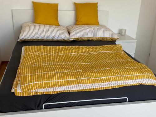 约伊斯Seevilla Matilda direkt am Ufer的一张配有黄色和黑色床单及枕头的床