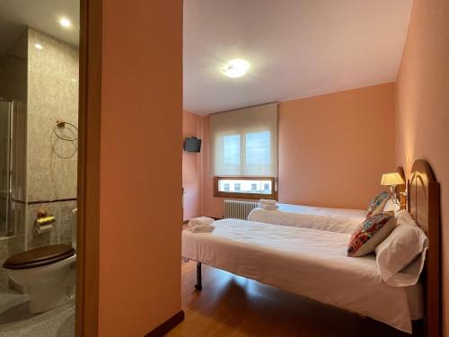 杜鲁埃洛德拉谢拉Hostal Restaurante Torreblanca的一间卧室设有两张床、淋浴和卫生间