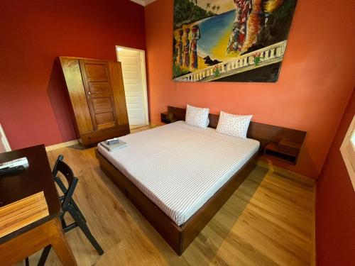 圣多美Residencial Avenida Geovanni的卧室配有红色墙壁内的一张床