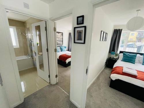 恩菲尔德Enfield Chase Apartment的一间带两张床的卧室和一间带镜子的浴室