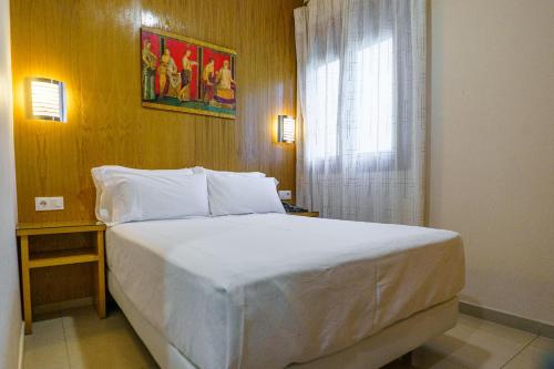 梅里达米拉格罗斯河渠旅馆的卧室设有一张白色大床和一扇窗户。