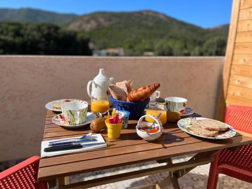 加莱里亚Résidence Casa TOGA的一张木桌,上面摆放着早餐食品