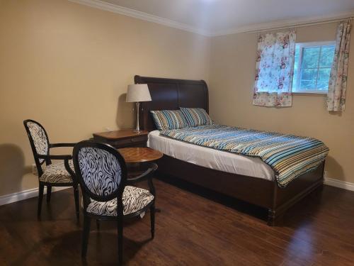 高贵林温哥华珍妮旅馆的一间卧室配有一张床、两把椅子和一张桌子