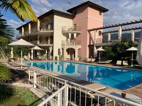 加尔达湖滨丽都特瑞酒店的一座带游泳池的度假村,位于一座建筑前