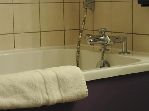Senones奥邦乡间度假别墅酒店的配有水龙头和毛巾的浴缸