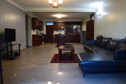 坎帕拉Munyonyo Heights Apartments的客厅配有沙发和桌子