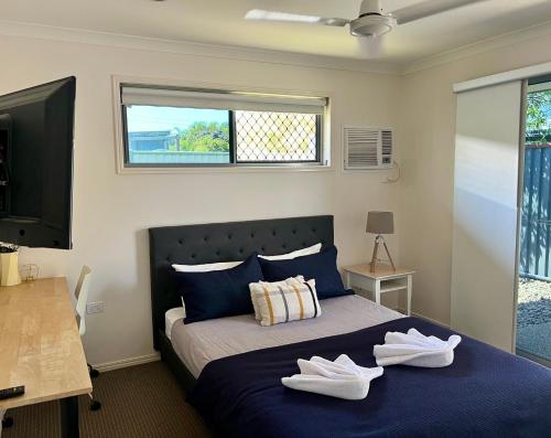 班达伯格Home away from home - Modern luxury in central Bundaberg的一间卧室,床上有两双白鞋