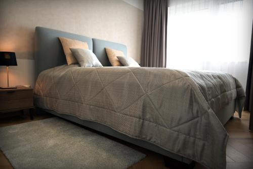 Šajdíkove HumenceApartmán Golfballs的卧室配有带枕头的床铺和窗户。