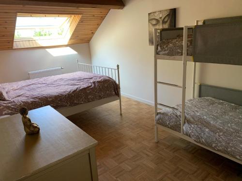 罗谢豪Maison de Rochehaut的一间卧室设有两张双层床和一张桌子