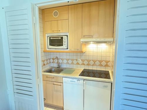 蒂涅Val Claret, Tignes T2 tout confort de 36m2的一间带水槽和微波炉的小厨房