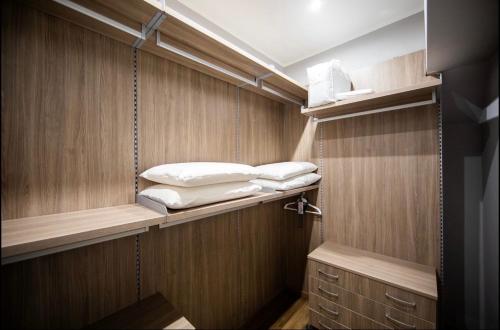 米兰NEW WONDERFUL BILO WITH WALK-IN CLOSET from Moscova Suites Apartments的小房间,架子上有一些枕头