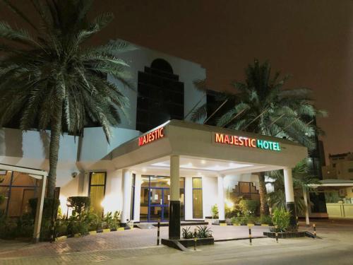 麦纳麦Majestic Hotel的棕榈树前的宏伟酒店