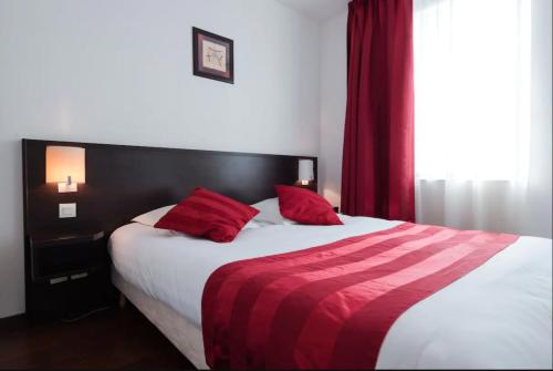 里昂Appart'City Classic Lyon Part-Dieu的一间卧室配有一张带红色枕头的大床