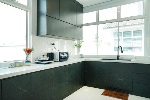 迪沙鲁Desaru KTV Classical Elegant Style by Joyfully 2M2的厨房配有黑色橱柜和水槽