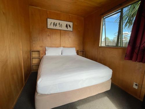 怀希比奇Athenree Hot Springs & Holiday Park的一个小房间的一个床位,设有窗户