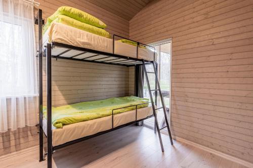 BražuolėBona Natura Nameliai的木墙内带两张双层床的客房