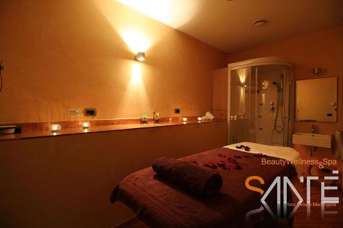 塞尔瓦迪法萨诺Hotel Castel Miramonti的卧室配有一张挂在墙上的灯光床。
