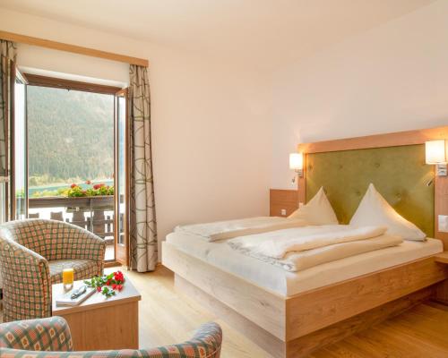 魏森湖魏森塞纳格勒霍夫酒店的酒店客房设有一张床和一个阳台。