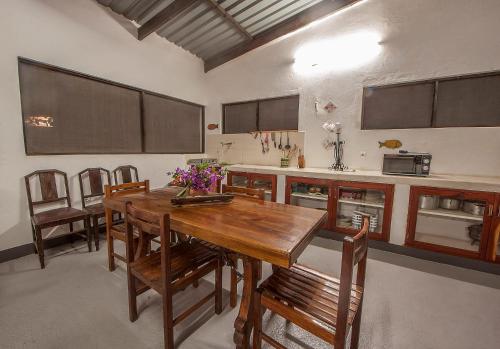 普拉伊拉多比莱尼Joao's Place的厨房配有木桌和一些椅子