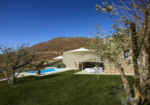 安德罗斯Heliades Villas Suite with private pool的一个带游泳池和遮阳伞的庭院