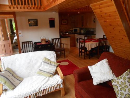 拉斯德拉姆Birchdale Cottage的一间带白色沙发的客厅和一间厨房