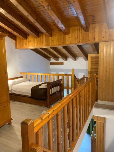 因克勒斯ABELLETES - K31 Deusol - Vall d'Incles - Soldeu的一间卧室设有一张床和木制楼梯。