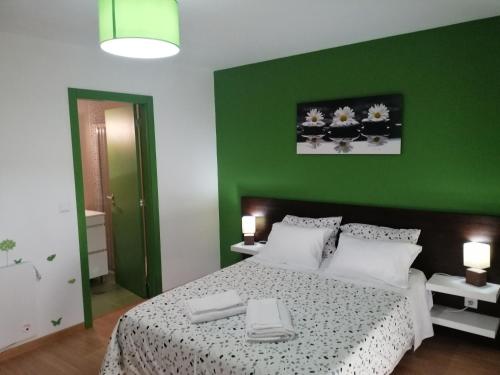 Cortes do MeioCasa do Adro - Serra da Estrela的一间卧室配有一张带绿色墙壁的床
