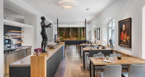 慕尼黑慕尼黑阿尔潘酒店的配有桌子和女人雕像的餐厅