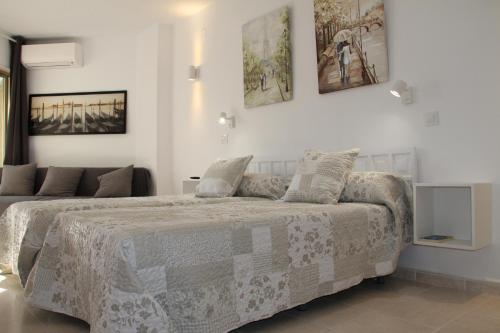 阿尔姆尼卡Estudio Luxury Primera Linea de Playa Almuñecar Parking Gratuito的白色卧室配有一张带毯子的床