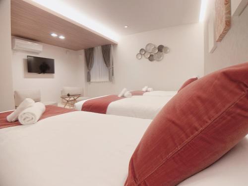 广岛HOTEL CLA-SS HIROSHIMA-TOKAICHI的酒店客房设有两张带大枕头的床