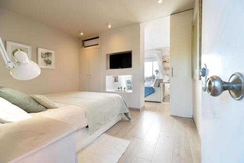 加瓦Gava Ocean View的一间白色卧室,配有床和电视