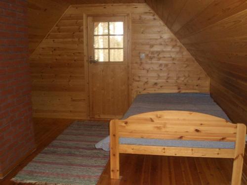 KarstulaArvola的小木屋内一间卧室,配有一张床