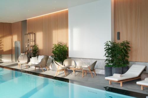 伦敦伦敦泛太平洋酒店的酒店大堂设有游泳池和椅子