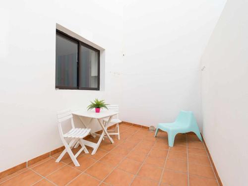 阿雷西费Mahostly Apartamento Comillas PH的客房设有桌椅和窗户。