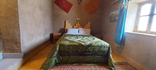 梅尔祖卡Gite GAMRA的卧室位于客房的角落,配有一张床