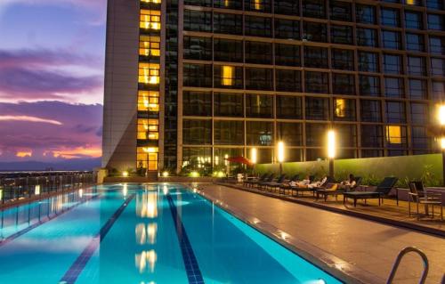 古晋古晋帝国酒店的一座游泳池,在晚上在建筑物前