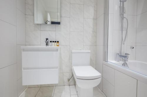 伦敦1VH Virginia House, 31 Bloomsbury Way by City Living London的白色的浴室设有卫生间和水槽。