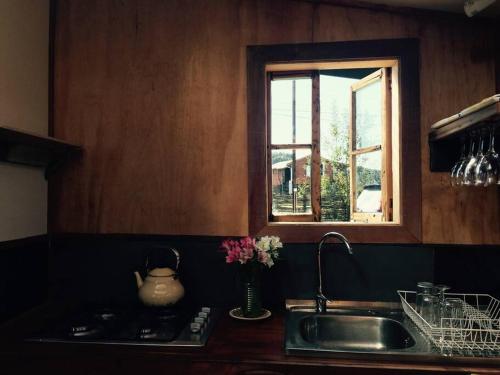 卡斯特鲁Casa Chakana Chiloé的带水槽的厨房台面和窗户