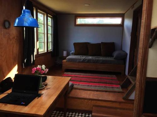 卡斯特鲁Casa Chakana Chiloé的客厅配有一张木制桌子上的笔记本电脑