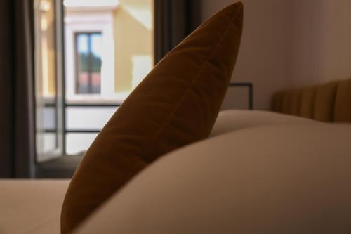 罗马Old Town Home Trastevere的一张带窗户的床上的棕色枕头