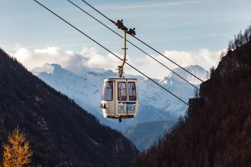 瓦托内切HelloChalet - Maison Rue de la Neige - Family Ski Holiday walking distance skirun and gondola的缆车正穿越群山
