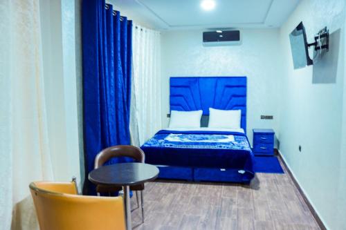 胡里卜盖HOTEL BORJ EL ARAB的一间卧室配有蓝色的床和桌椅