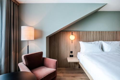 法灵登Mollie's Motel & Diner Oxfordshire的配有一张床和一把椅子的酒店客房