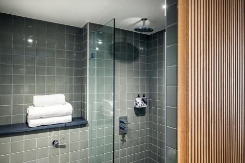 法灵登Mollie's Motel & Diner Oxfordshire的带淋浴的浴室和绿色瓷砖墙壁