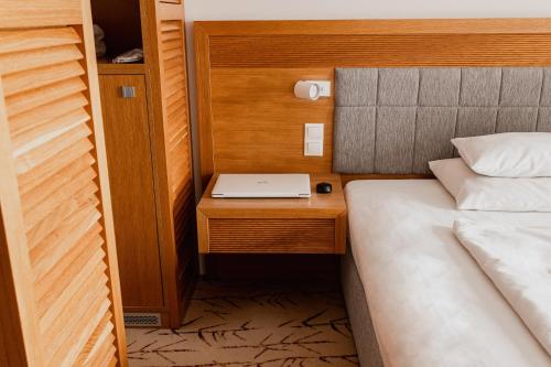 奥尔什丁Hotel Marina Club的一间卧室配有一张床和一张桌子上的笔记本电脑
